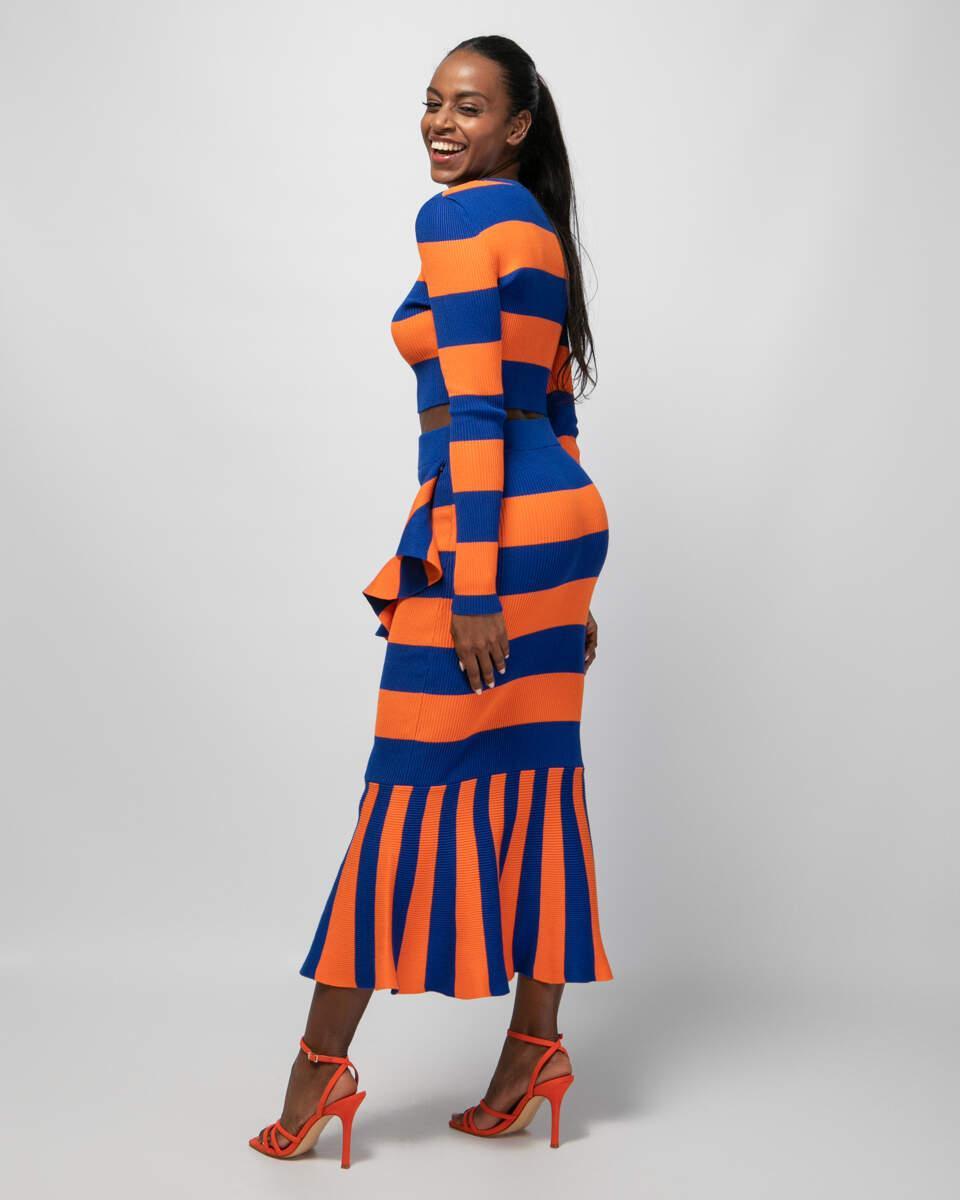 Midi ριγέ μπλε με πορτοκαλί φούστα με στενή εφαρμογή, ελαστική μέση και λεπτομέρειες με βολάν. Εμφάνιση στο πλάι