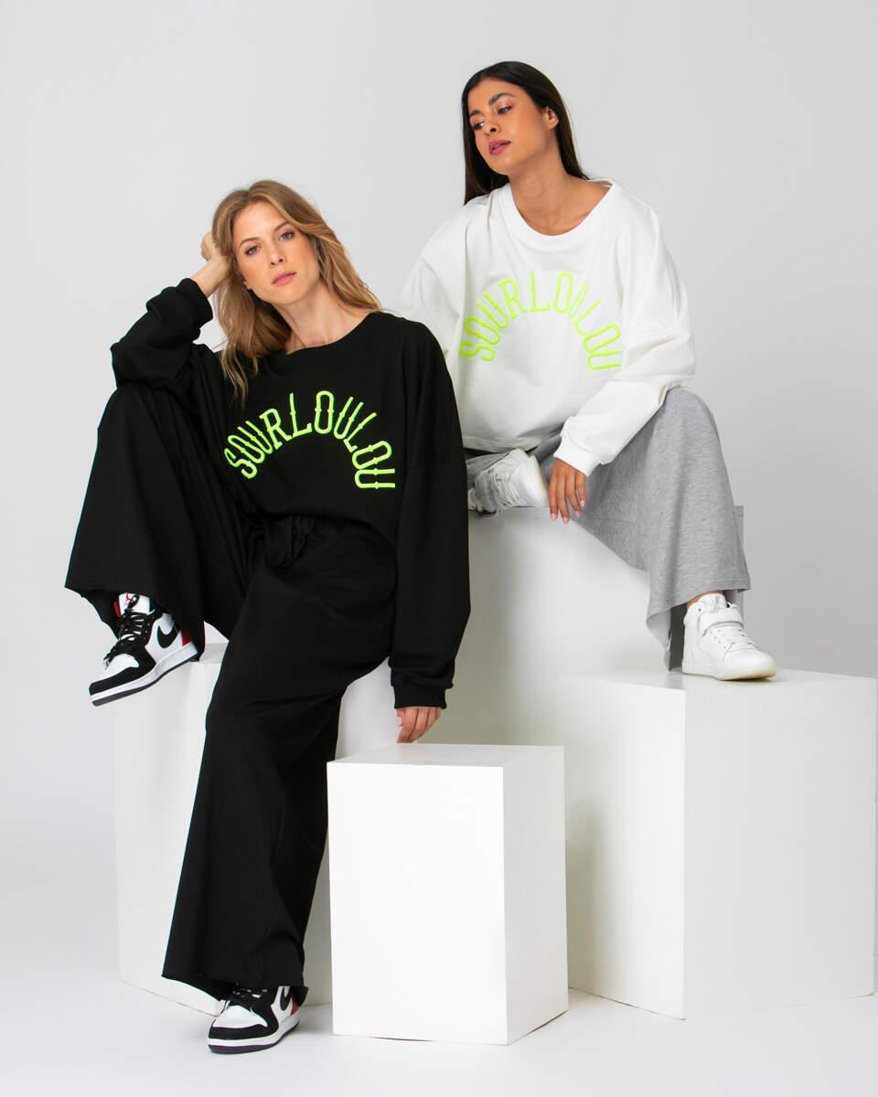 Oversized φούτερ μπλούζα με τυρκουάζ γράμματα το λογότυπο της sourloulou. Κοντύτερο κόψιμο μπροστά. Σε εκρού και μαύρο