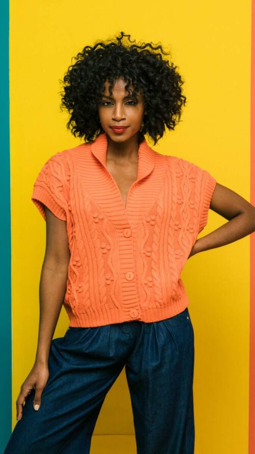 plekti-amaniki-zaketa-portokali-mprosta Πλεκτή αμάνικη πορτοκαλί ζακέτα με V λαιμόκοψη, άνοιγμα στην πλάτη και μπροστά κουμπιά. Εμφάνιση από μπροστά