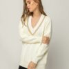 Πλεκτή εκρού μπλούζα με χρυσό V γιακά. Εμφάνιση στο πλάι