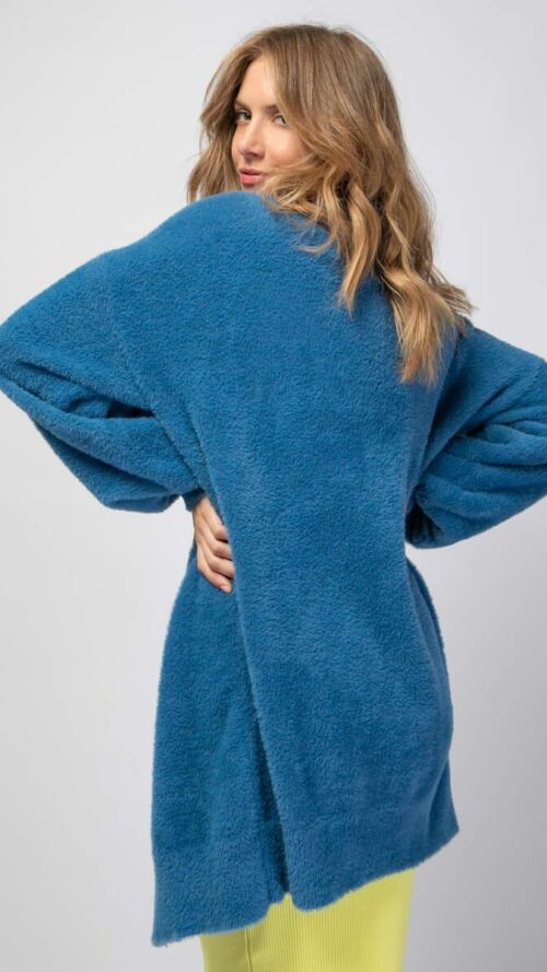 Πλεκτή fluffy ζακέτα με ένα χρυσό κουμπί. Εμφάνιση από πίσω.