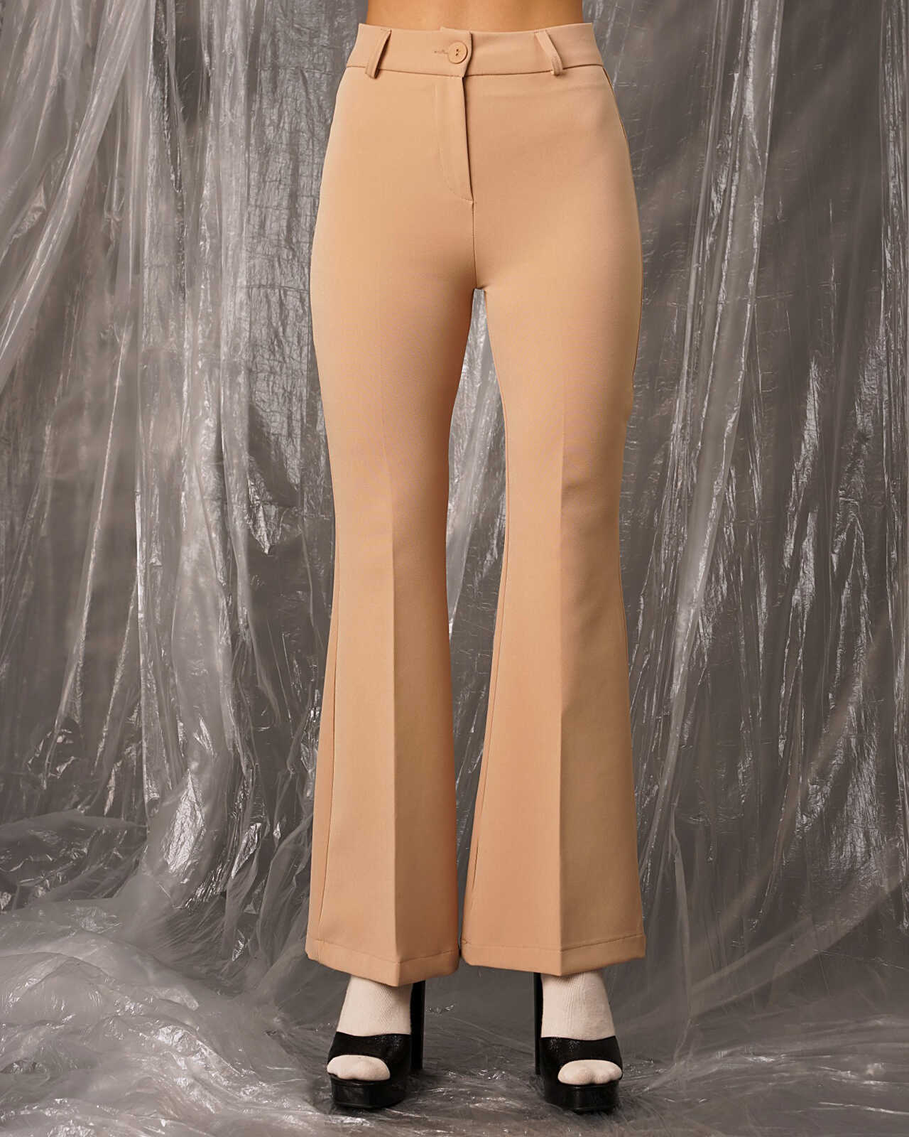 Ψηλόμεσο κάμελ παντελόνι καμπάνα χώρις τσέπες. Κλείσιμο με κουμπί και φερμουάρ. Εμφάνιση από μπροστά