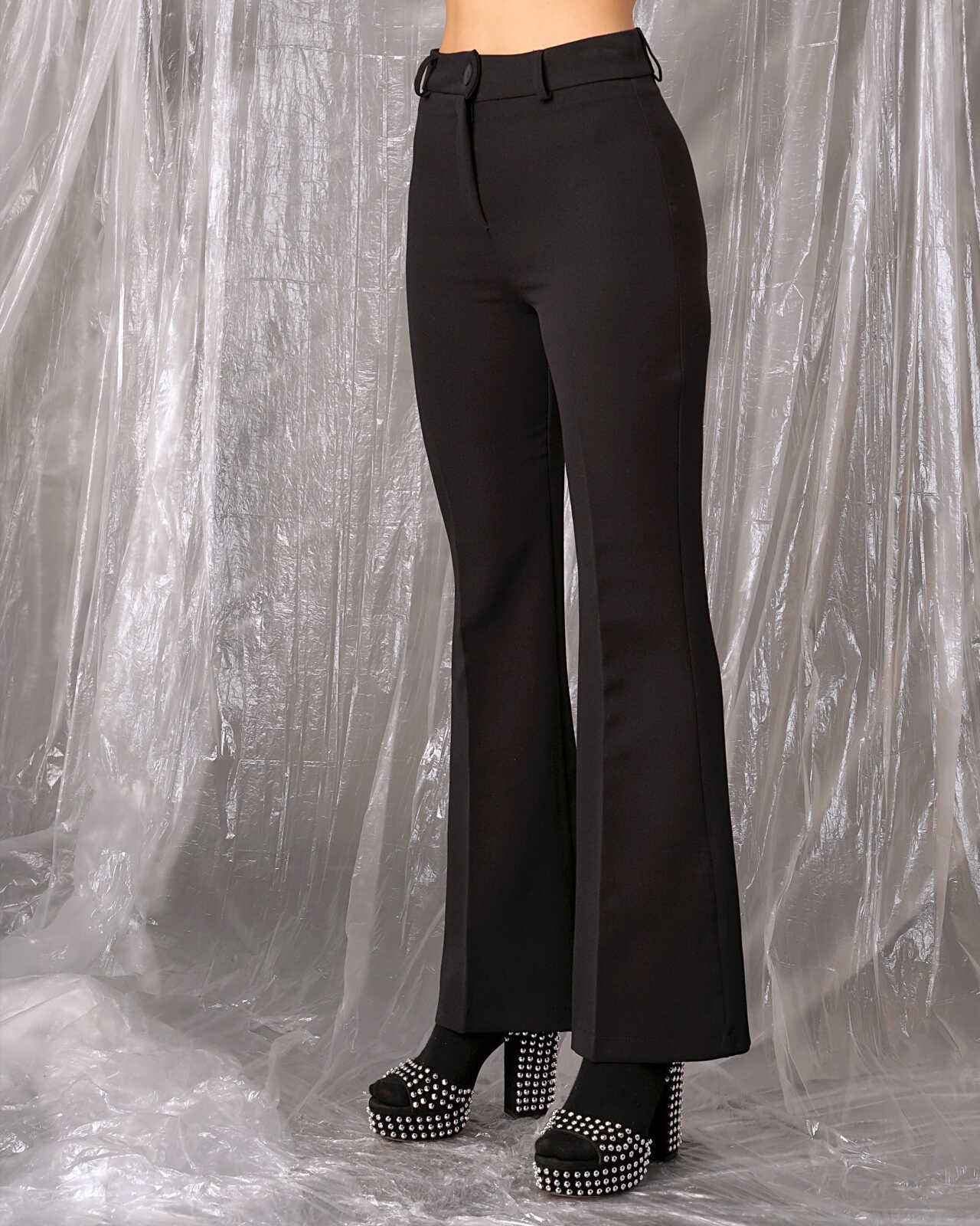 Ψηλόμεσο μαύρο παντελόνι καμπάνα χώρις τσέπες. Κλείσιμο με κουμπί και φερμουάρ. Εμφάνιση από μπροστά